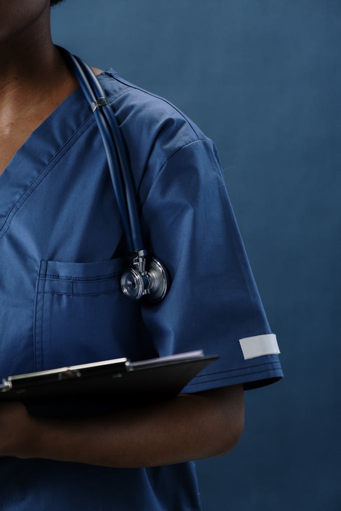 Zdjęcie autorstwa cottonbro studio Close-up of a healthcare professional in blue scrubs with a stethoscope and clipboard.